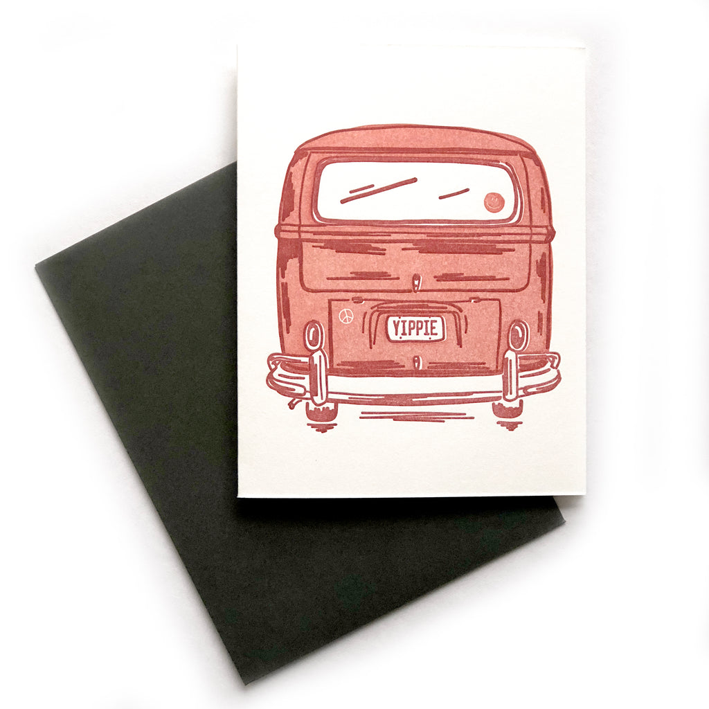 White card with image of the rear view of a red vintage van with red text on the license plate saying, “YIPPIE”. A black envelope is included.