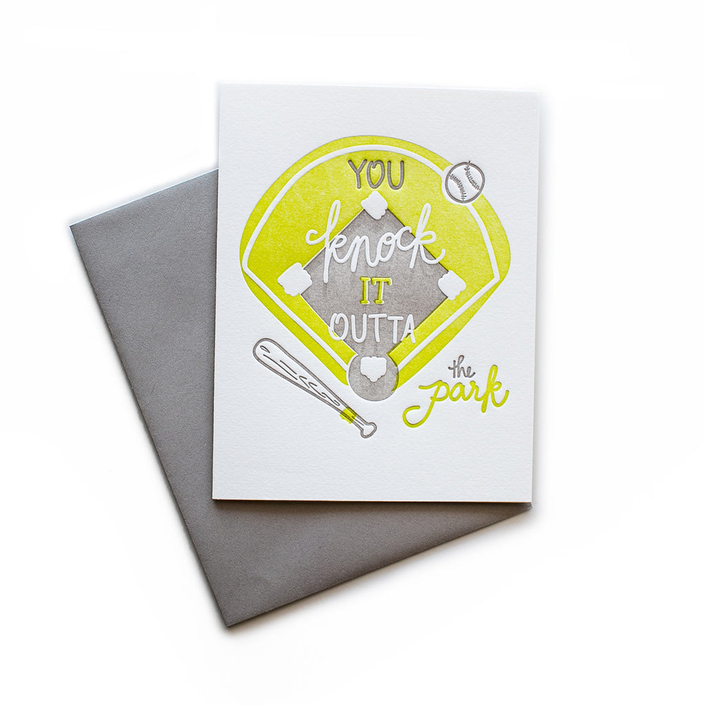 White card with gray and yellow text saying, “You Knock It Outta the Park”. Image of a yellow baseball diamond and gray baseball bat and ball. A gray envelope is included.