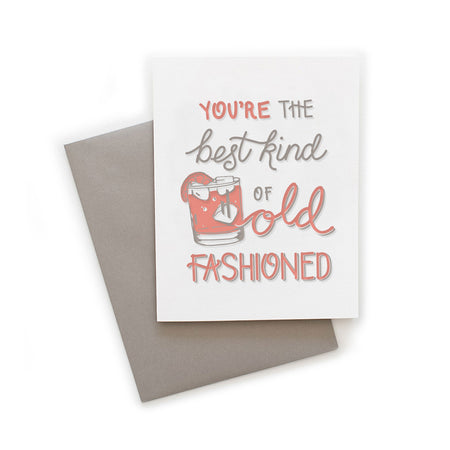 White card with gray and pink text saying, “You’re  the Best Kind of Old Fashioned”. Image of a gray and pink Old Fashion drink with white ice cubes. A gray envelope is included.