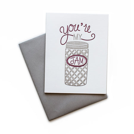White card with gray and purple text saying, “You’re My Jam”. Image of a gray and purple jar of jam. A gray envelope is included.