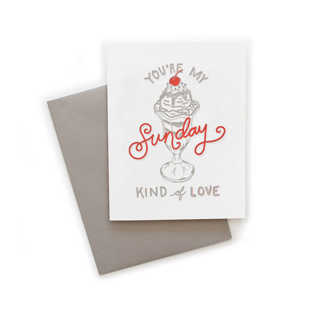 White card with gray and red text saying, “You’re My Sunday Kind of Love”. Image of a gray ice cream sundae with a red cherry on top. A gray envelope is included.
