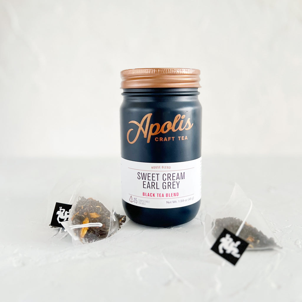 Blue jar with brass lid and white label. Brown text saying, “Apolis Craft Tea”. White label with blue and red text saying, “Sweet Cream Earl Grey Black Tea Blend”.