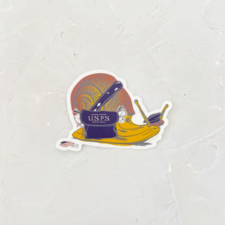 White sticker in the image of a yellow and red snail dressed as a postal worker with a blue hat and a blue mailbag.