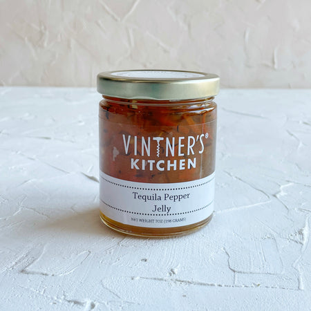 Glass jar with metal lid. White text saying, “Vintner’s Kitchen Tequila Pepper Jelly”.
