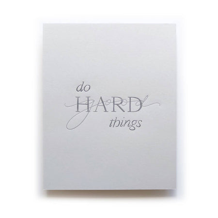 Print with gray background and navy text saying, “Do Hard Things”. Images of the word “Good” overlay on the word hard. An envelope is included.