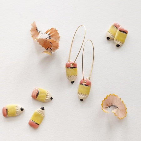 Small earrings in the image of a traditional pencil with pink eraser, silver band, and yellow pencil with black tip.