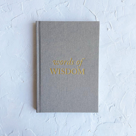   Gray color journal with gold foil text saying, “Words of Wisdom” in center.